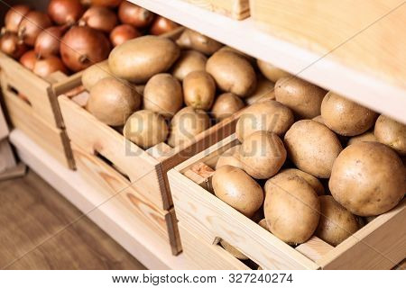 Crates With Potatoes And Onions On Shelf. Orderly Storage
