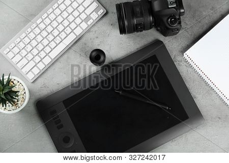 Flat Lay Composition With Graphic Tablet And Camera On Grey Stone Table, Space For Text. Designer's 