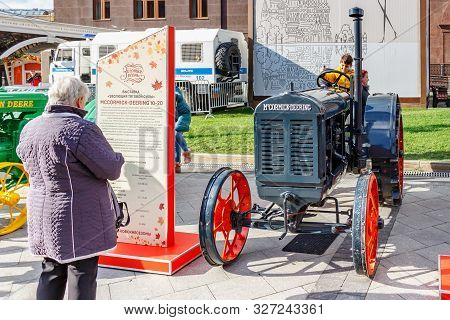 Moscow, Russia - October 08, 2019: People Near American Arable Wheel Tractor Mccormick-deering. Exhi