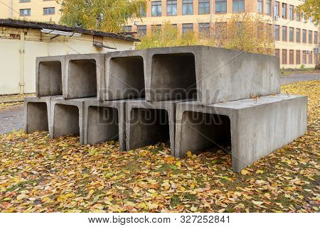A Stack Of Reinforced Concrete Trays For A Heating Main On An Autumn Street. Preparation For Constru