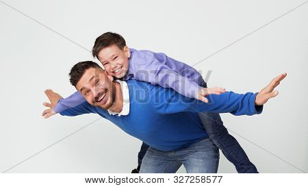 Happy Dad And Son Playing Together, Man Riding Boy On Back Like Flying On Plane, White Panorama Back