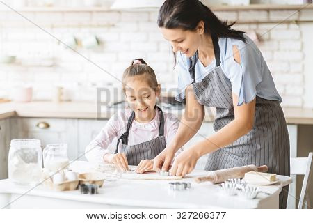 Mom And Daughter Making Cookies Together In Kitchen, Pressing Dough With Cutter, Copy Space