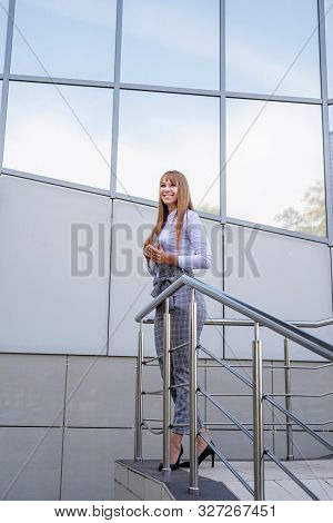 Business Woman Concept. Beautiful Caucasian Business Woman Standing Next To The Building Smiling Hld