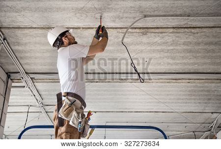 Electrician Installer With A Tool In His Hands, Working With Cable On The Construction Site. Repair 