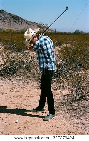 Young Boy In Natural Terrain Desert Golfing