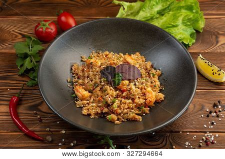 Ebi Chahan Fried Japanese Rice With Vegetables, Shrimp And Soy Sauce In A Black Plate On A Wooden Ba