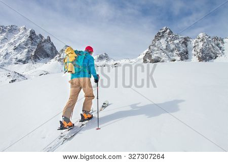 Rear View Of Skier Hiking To Mountain Summit