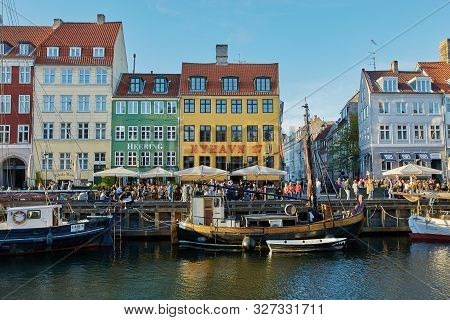 Colourful Facades And Restaurants On Nyhavn Embankment And Old Ships Along The Nyhavn Canal In Copen