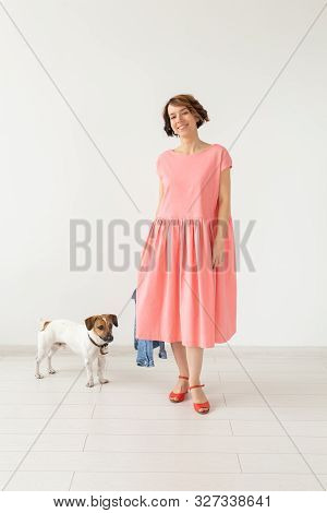 Pet And People Concept - Young Woman In Pink Dress With Jack Russell Over The White Background