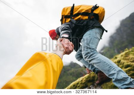 Pov View On Brave Tourist Helping His Active Friend Holding To Hand Climbing To Rock. Two Travelers 
