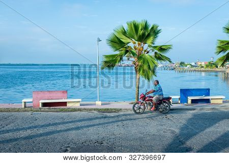 Tumaco, Nariño / Colombia, January 17 2019: Black Man Cruising A Bridge Near The Port In Motorcycle 