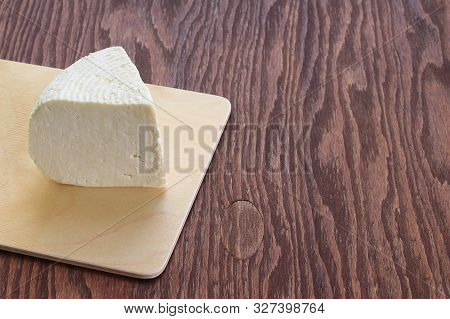 Adyghe Cheese On A Cutting Board. Brown Wood Background