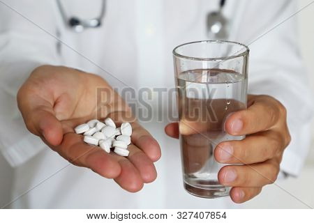 Doctor Giving Pills And Glass Of Water, Physician Holding In Palm Of Hand Medication In White Tablet