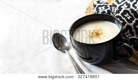 Cauliflower Soup (creme Du Barry) In Black Bowl On White Background With Black And White Cloth. Copy