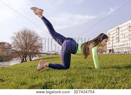 1 White Girl With Long Hair In Sportswear Doing Fitness, Lifting Her Legs In The Air