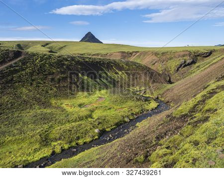 Volcanic Landscape Of Green Storasula Mountain With Lush Moss And Blue Creek Water Between Emstrur A