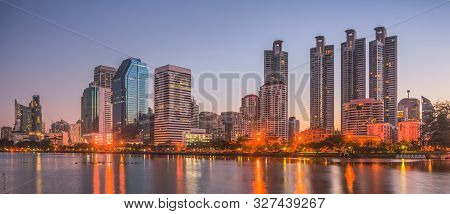 Lake In City Park Under Skyscrapers At Twilight. Benjakiti Park In Bangkok, Thailand
