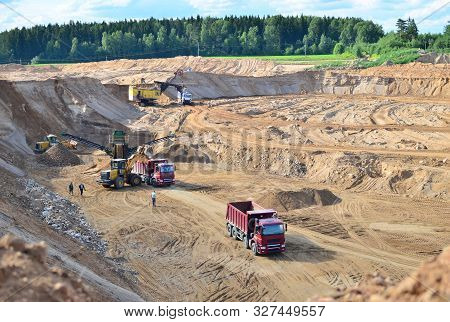 Wheel Front-end Loader Loads Sand Into A Dump Truck. Heavy Machinery In The Mining Quarry, Excavator
