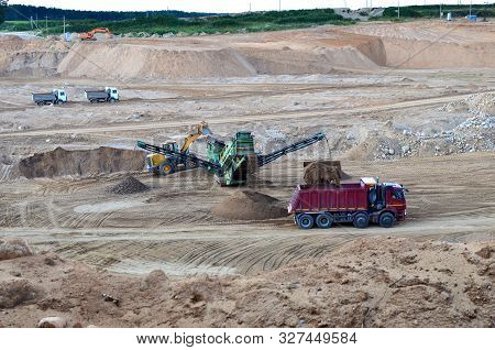 Wheel Front-end Loader Loads Sand Into A Dump Truck. Heavy Machinery In The Mining Quarry, Excavator