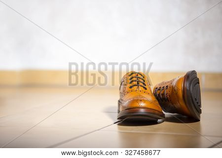 Pair Of Luxury Male Full Brogued Tan Oxford Shoes. Placed Together On Tiles Floor. Horizontal Image 