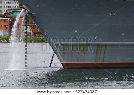 Big Ship Hauling Up The Anchor. Small Seagulls On The Huge Bow Background.