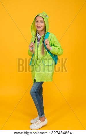 She Is Cool. Happy Small Child Wear Fashion Rain Jacket On Yellow Background. Small Child Smiling Wi