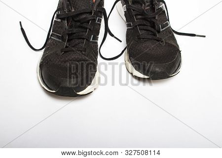 Old, Worn Sneakers With Holes On A White Background. Concept Of Running, Marathon, Ultramarathon, Lo