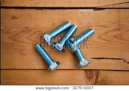 Some Metalware On The Wooden Background (self-tapping Screws, Bolts)