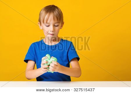 Cute Little Boy Plays With Green Slimes In Kindergarten. Kid Making A Slime At Creative Class. Popul