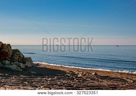 The Dark Sands And Calm Surf Of The Bering Sea In Nome Alaska.