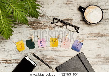 Jueves Sign And A Cup Coffe On A Desk (thursday)