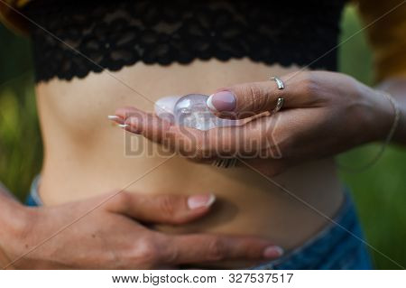 Female Hands Holding Two Yoni Eggs For Vumfit, Imbuilding Or Meditation Are Made From Pink Quartz An