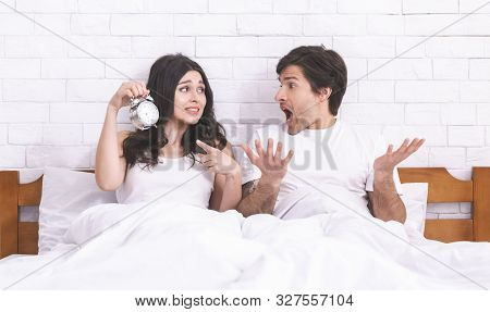 Overslept. Young Panicked Couple Missed Ringing Of Alarm Clock And Late, Sitting In Bed, Panorama, C