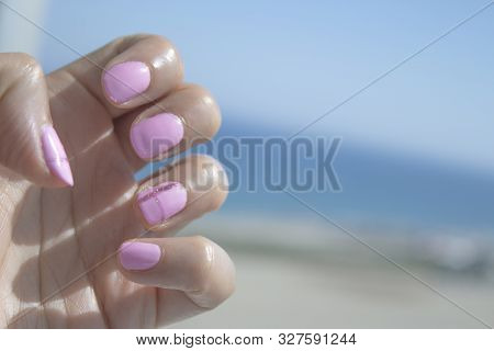 Semipermanent Pink Gel Painted Nails. Blue Background