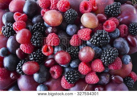 Background Of Fresh Vegetables And Fruits. Ripe Blackberries, Blueberries, Plums, Pink Grapes, Raspb