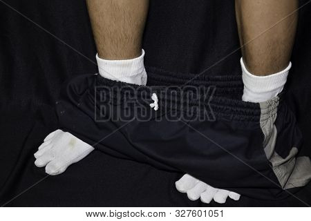 Asian Man Removing His Trousers Down Isolated On Black Background