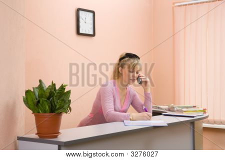 Nainen vastaanottovirkailija puhuu puhelimeen