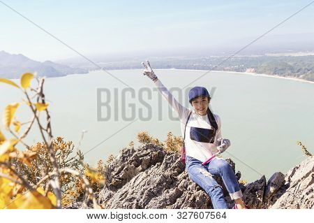 Asian Woman Is Raising Her Hand To Show How Happy It Was To Successfully Shoot A Mountaintop With Se