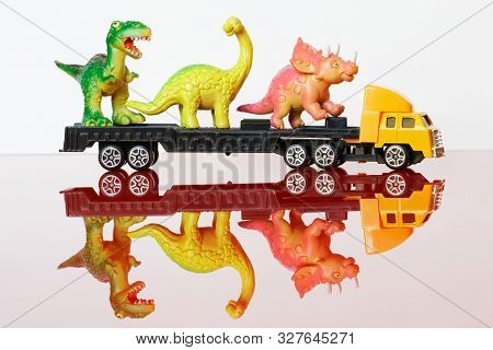 A Large Truck Carries Dinosaurs To The Reserve, To The Farm Or To The Meat Factory. Cargo Transporta