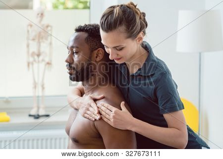 Remobilization of shoulder joint of young man in the physical therapy