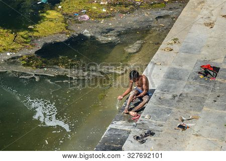 Udaipur, India - February 17, 2019: Indian Boy Washing In The Lake Swaroop Sagar Lake In Udaipur. Ra