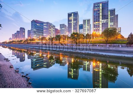 Beijing, China CBD city skyline and canal at night.