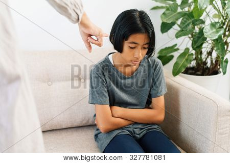 Asian Mother Is Angry And Scold Her Daughter While Sitting On The Sofa Because Of Bad Behavior. The 