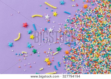 Sprinkles On Purple Background - Cake Topping Sprinkles Sprayed On Lilac Background - Top View