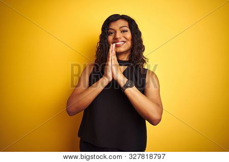 Transsexual transgender elegant businesswoman standing over isolated yellow background begging and praying with hands together with hope expression on face very emotional and worried. Asking