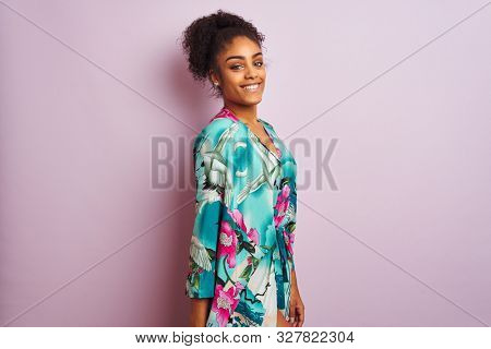 Young beautiful african american woman standing wearing elegant colorful caftan