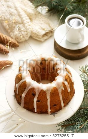 Pie With Raisins And Icing From Powdered Sugar On The Background Of Fir Branches And Garlands. Rusti