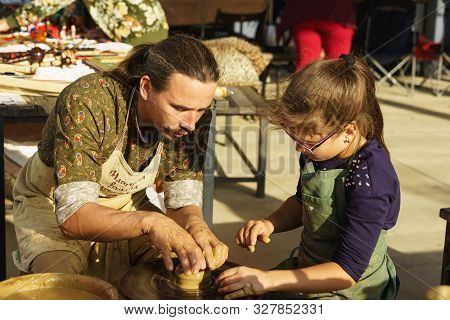 Moldavanskoye, Krymsk, Russia-05 October 2019: A Potter Teaches A Girl How To Make A Pitcher Of Clay