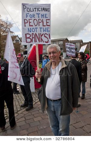 Andrew Duncan fra Exeter Anti-cuts Allience, holder et skilt siger 