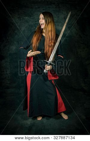 Full Length Portrait Of Young Long Haired Woman Wearing A Medieval Costume. Standing Pose Presenting
